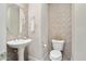 Stylish powder room with decorative tile wall, pedestal sink, and modern fixtures, creating an elegant space at 29344 N 132Nd Ln, Peoria, AZ 85383