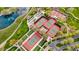 Aerial view of red and green tennis courts with walking paths, landscaping, and nearby pond at 29344 N 132Nd Ln, Peoria, AZ 85383