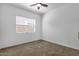 Minimalist bedroom with carpeted floors, a ceiling fan, and a large window at 2962 E Birdsong Ave, San Tan Valley, AZ 85143