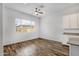 Dining area with wood floors, a large window, and modern white cabinets at 2962 E Birdsong Ave, San Tan Valley, AZ 85143