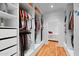 Walk-in closet showcasing custom shelving, hardwood floors, and access to the en-suite bathroom at 307 E Catalina Dr, Phoenix, AZ 85012
