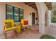 Inviting covered porch with colorful chairs, terracotta tiles, and architectural details at 307 E Catalina Dr, Phoenix, AZ 85012