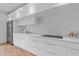 Modern kitchen featuring white cabinets, stainless steel appliances and white backsplash at 307 E Catalina Dr, Phoenix, AZ 85012