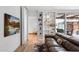 Bright living room featuring a bookshelf, modern couch, hardwood floors, and a television at 307 E Catalina Dr, Phoenix, AZ 85012