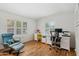 Home office with hardwood floors, a white built-in desk, and large windows with shutter blinds at 307 E Catalina Dr, Phoenix, AZ 85012