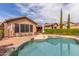 Backyard pool with rock features, an umbrella table, and a well manicured garden at 3613 W Plymouth Dr, Anthem, AZ 85086