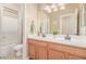 Bright bathroom featuring a double vanity, large mirror, and a shower/tub combo with a white shower curtain at 3613 W Plymouth Dr, Anthem, AZ 85086