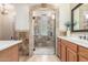Bathroom with a walk-in shower, a glass door, vanity with framed mirror, and stone tile at 3613 W Plymouth Dr, Anthem, AZ 85086