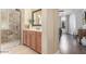 Bathroom with glass shower stall, wood cabinets, light tile, and natural light at 3613 W Plymouth Dr, Anthem, AZ 85086