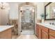 Bathroom with stone tiled shower stall, tile accents, wood cabinets, and stone-framed mirror at 3613 W Plymouth Dr, Anthem, AZ 85086