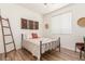 Cozy bedroom with minimalist decor featuring a metal bed frame, textured wall hangings, and wood-look floors at 3613 W Plymouth Dr, Anthem, AZ 85086