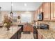 Gourmet kitchen featuring granite countertops, stainless steel appliances, and warm wood cabinetry at 3613 W Plymouth Dr, Anthem, AZ 85086