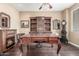 Elegant home office with rich hardwood floors, bespoke shelving, and a traditional fireplace at 3613 W Plymouth Dr, Anthem, AZ 85086
