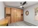 Bedroom with a full-wall built-in closet with wooden doors and modern ceiling fan at 4043 S Shady Ct, Gilbert, AZ 85297