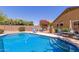 Backyard featuring swimming pool, lush landscaping, privacy fence, patio furniture, and grill at 4043 S Shady Ct, Gilbert, AZ 85297
