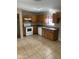 Bright kitchen with wood cabinets, white appliances, and tile flooring, ready for your personal touch at 4119 N 105Th Ln, Phoenix, AZ 85037