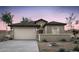 Charming single-story home featuring a stucco exterior, tile roof, and a two-car garage against a picturesque desert landscape at 42885 W Vincent Dr, Maricopa, AZ 85138