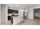 Bright kitchen with stainless steel appliances, granite countertops, a center island with seating, and ample cabinet space at 42885 W Vincent Dr, Maricopa, AZ 85138