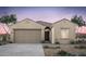Inviting single-story home featuring desert landscaping, tile roof, and attached two-car garage at 42935 W Peters Dr, Maricopa, AZ 85138