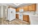 Kitchen featuring bright wood cabinetry, white appliances, wood floors, and a refrigerator with water dispenser at 4301 N 21St St # 3, Phoenix, AZ 85016