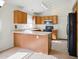 Cozy kitchen with oak cabinets, a breakfast bar, and modern appliances at 44010 W Wade Dr, Maricopa, AZ 85138