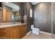 Modern bathroom featuring a wood vanity, textured walls, and glass-enclosed shower with updated fixtures at 4416 N 37Th Way, Phoenix, AZ 85018