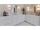 Elegant bathroom featuring double sinks, white cabinetry, and a decorative plant, creating a serene atmosphere at 4416 N 37Th Way, Phoenix, AZ 85018