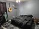 Simple bedroom featuring dark walls, guitar on the wall and a comfortable bed. Great for relaxation and rest at 4507 E Saint Catherine Ave, Phoenix, AZ 85042
