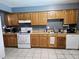 Functional kitchen with wooden cabinets, white appliances, and tiled floors, providing ample space for meal preparation at 4507 E Saint Catherine Ave, Phoenix, AZ 85042