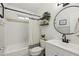 This bathroom features a shower-tub combo and a round mirror above the vanity at 510 N Alma School Rd # 252, Mesa, AZ 85201
