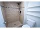 Shower features earth-toned tiles and black shower head at 5217 N 18Th Dr, Phoenix, AZ 85015