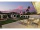Outdoor oasis showcasing a pergola, inviting seating areas, and lush landscaping under the sunset at 5238 E Beck Ln, Scottsdale, AZ 85254
