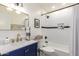Charming bathroom with blue vanity, gold fixtures, and subway tile shower with built in niche at 5238 E Beck Ln, Scottsdale, AZ 85254