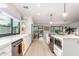 Bright, open kitchen with modern appliances, white cabinetry, and large windows for natural light at 5238 E Beck Ln, Scottsdale, AZ 85254