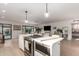 Open kitchen with island, stainless appliances and view to living room and outdoor space at 5238 E Beck Ln, Scottsdale, AZ 85254