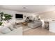 Open-concept living room with stylish furniture, a modern entertainment center, and seamless flow to other areas at 5238 E Beck Ln, Scottsdale, AZ 85254