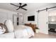 Comfortable bedroom with barn door access to bathroom, TV, and natural light at 5238 E Beck Ln, Scottsdale, AZ 85254