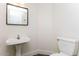 This modern powder room features a pedestal sink, toilet, and stylish wood-look flooring at 5329 E Harmony Ave, Mesa, AZ 85206