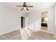 Bright bedroom featuring neutral carpet, ceiling fan, and view to bathroom at 5329 E Harmony Ave, Mesa, AZ 85206