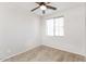 Cozy bedroom featuring a ceiling fan and a bright window with neutral carpet flooring at 5329 E Harmony Ave, Mesa, AZ 85206