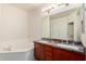 Bright bathroom with a soaking tub, double sink vanity, and elegant granite countertop at 5450 E Deer Valley Dr # 4199, Phoenix, AZ 85054