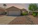 Charming single-story home with a well-maintained yard, desert landscaping, and a two-car garage at 6027 E Sayan Cir, Mesa, AZ 85215
