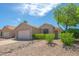 Charming single-story home with desert landscaping, complemented by lush green bushes at 6027 E Sayan Cir, Mesa, AZ 85215