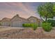 Charming single-story home with desert landscaping, complemented by lush green bushes at 6027 E Sayan Cir, Mesa, AZ 85215