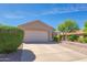 Well-maintained single-story home featuring a two-car garage and desert landscaping at 6027 E Sayan Cir, Mesa, AZ 85215