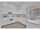 Well-lit kitchen featuring white cabinets, sleek countertops, and modern appliances at 6027 E Sayan Cir, Mesa, AZ 85215