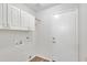 Bright laundry room with plenty of cabinet space and a door to the outside at 6027 E Sayan Cir, Mesa, AZ 85215