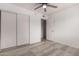 Bright bedroom features a modern ceiling fan, wood-look floors, and a spacious closet at 6038 W Gelding Dr, Glendale, AZ 85306