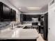 Bright kitchen showcases black cabinets, stainless steel appliances, stylish backsplash, and a clean, modern design at 6038 W Gelding Dr, Glendale, AZ 85306