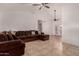 Bright living room featuring a vaulted ceiling, tile floors and a comfortable brown sectional couch at 6038 W Gelding Dr, Glendale, AZ 85306